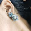 Silver flower pot earrings inspired by Kalash culture, crafted with intricate silver detailing.