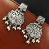 A close-up view of silver floral art earrings dangling elegantly.