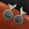 Silver Replica Peacock Earrings resting on a black velvet background