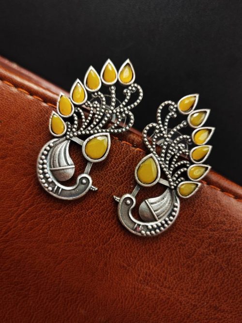 Peacock Stud Earrings displayed against a rustic backdrop.