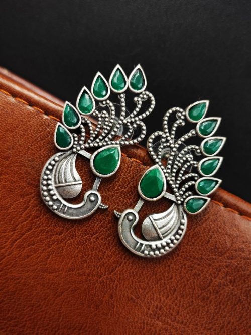 Peacock Stud Earrings displayed against a rustic backdrop.