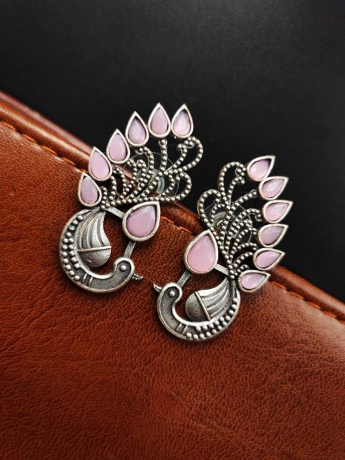 Peacock Stud Earrings displayed against a rustic backdrop.