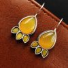 Silver Replica Stone Earrings with oxidized hooks displayed against a textured background