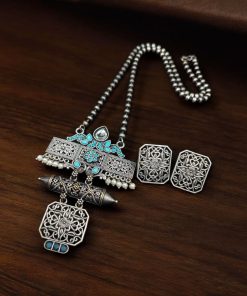 Silver look necklace set with a unique oxidized pendant and matching earrings featuring intricate detailing.