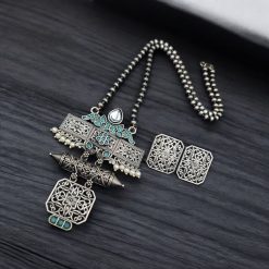 Silver look necklace set with a unique oxidized pendant and matching earrings featuring intricate detailing.