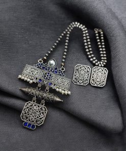 Silver look necklace set with a unique oxidized pendant and matching earrings featuring intricate detailing.