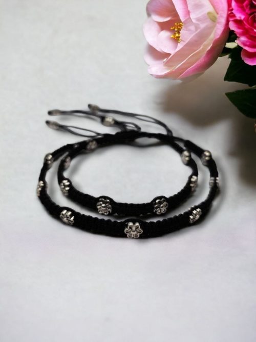 Elegant daily wear anklets with intricate thread work and flower charms in German silver, designed for a graceful and comfortable fit.