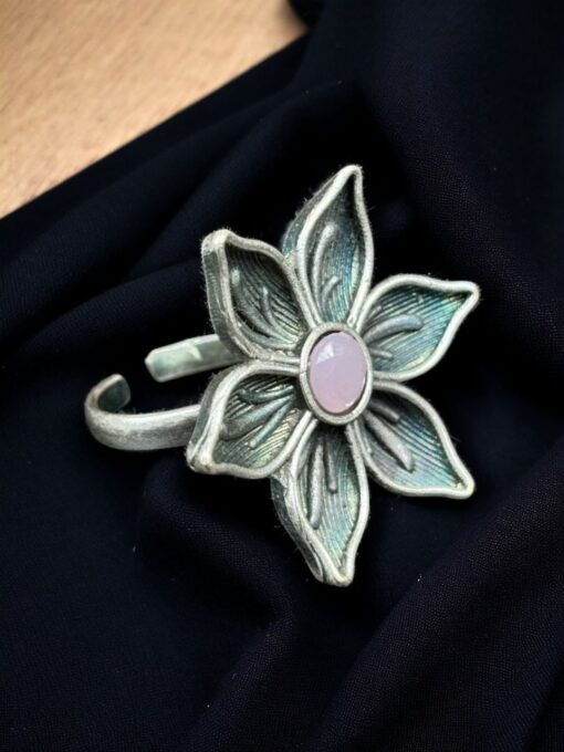 An elegant adjustable brass flower ring featuring a delicate flower motif with a sparkling stone detail, perfect for any occasion