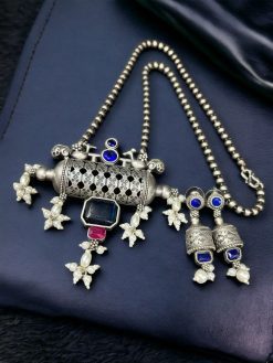 An elegant ethnic brass necklace featuring a bird motif and Monalisa stone, paired with matching earrings for a complete, sophisticated look