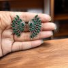 Handcrafted ancient feather style earrings with silver replica wings and intricate stone work.