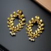 Golden leaf stud earrings with pearl accents for daily ethnic wear.