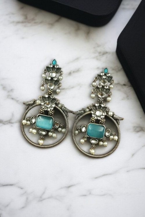Silver look-alike bird earrings with stone and pearl work in oxidized finish.