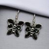 Oxidized butterfly hook earrings with stone work in silver plated finish.
