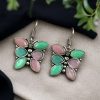 Oxidized butterfly hook earrings with stone work in silver plated finish.