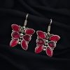 Oxidized butterfly hook earrings with stone work in silver plated finish.