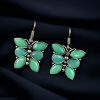 Oxidized butterfly hook earrings with stone work in silver plated finish.