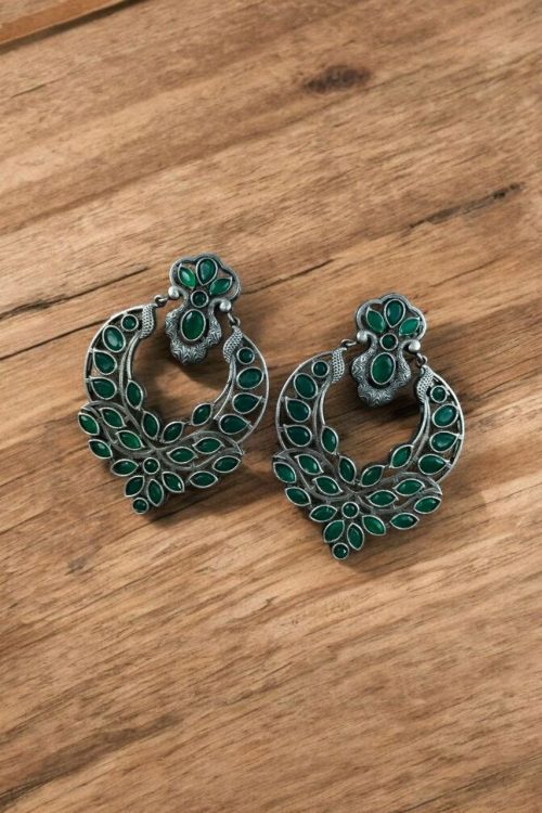 Oxidized silver replica dangler earrings with peacock design and stone work.