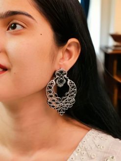 Oxidized silver replica dangler earrings with peacock design and stone work.