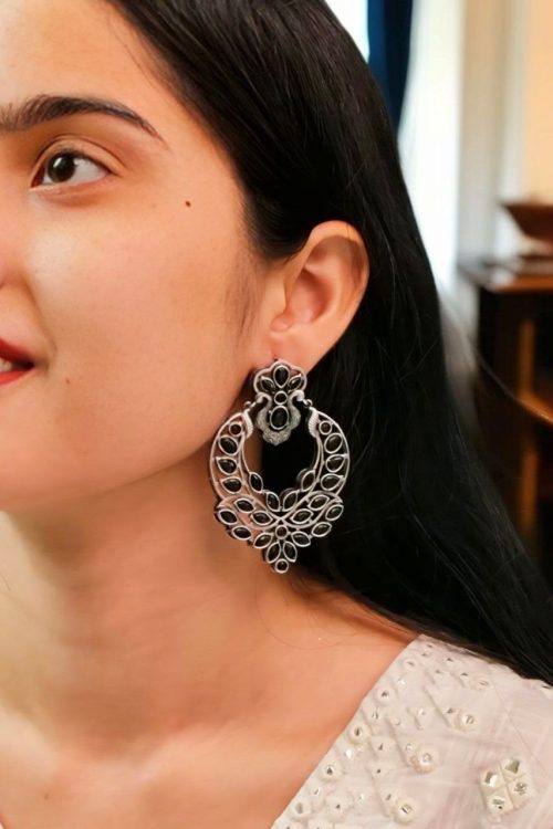 Oxidized silver replica dangler earrings with peacock design and stone work.