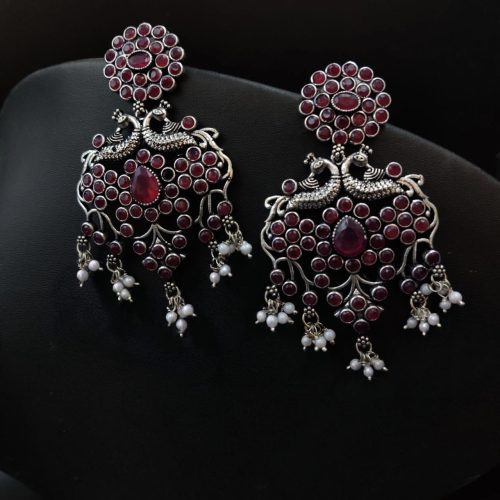 Handcrafted silver-plated peacock earrings with pearl and stone embellishments.
