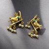 Handcrafted gold-plated bird earrings with pearl detailing.