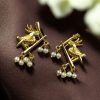 Handcrafted gold-plated bird earrings with pearl detailing.