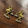 Handcrafted gold-plated bird earrings with pearl detailing.