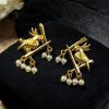 Handcrafted gold-plated bird earrings with pearl detailing.