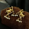 Handcrafted gold-plated bird earrings with pearl detailing.