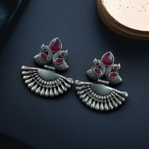 Handcrafted oxidized silver-plated peacock dangler earrings with stone detailing and pearl accents.