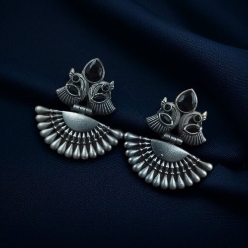 Handcrafted oxidized silver-plated peacock dangler earrings with stone detailing and pearl accents.