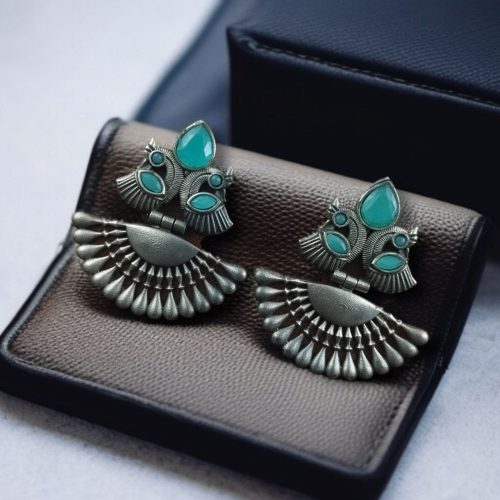 Handcrafted oxidized silver-plated peacock dangler earrings with stone detailing and pearl accents.