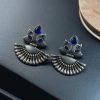 Handcrafted oxidized silver-plated peacock dangler earrings with stone detailing and pearl accents.