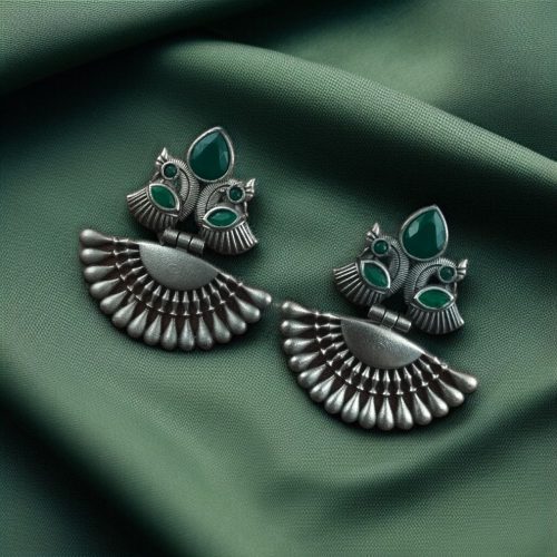 Handcrafted oxidized silver-plated peacock dangler earrings with stone detailing and pearl accents.