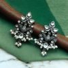 Close-up of handcrafted brass bird stud earrings with embedded beautiful stones, nature-inspired jewelry design