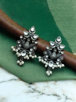 Close-up of handcrafted brass bird stud earrings with embedded beautiful stones, nature-inspired jewelry design