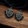 Close-up of silver-plated brass peacock earrings adorned with sparkling stones, featuring intricate ethnic detailing