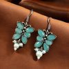 Pair of beautiful brass butterfly hook earrings with sparkling stone accents, ideal for daily wear