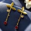 Premium gold-plated brass long stud earrings featuring sparkling Monalisa stones, perfect contemporary design.