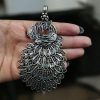 Handcrafted German silver pendant featuring an intricate peacock design, made with DIY jewelry crafting materials.