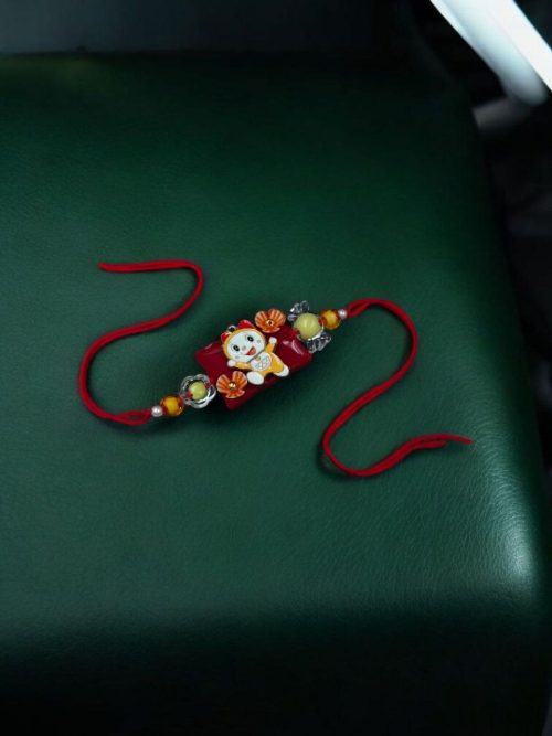 Alt Text: Gold plated Dorami Rakhi for brother.