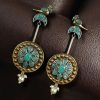 Two-tone traditional bird design dangler earrings with pearl and stone work