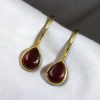 Gold plated drop shape earrings with stone work and hook dangler design