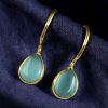 Gold plated drop shape earrings with stone work and hook dangler design