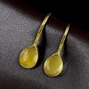 Gold plated drop shape earrings with stone work and hook dangler design