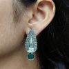 Traditional oxidized silver stud earrings with floral art, pearl, and stone work.