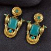 Traditional gold plated earrings with bird design and green stones in vintage style.