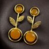 Gold plated floral art earrings with Monalisa stone and leaf design for ethnic and western wear.