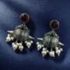 Traditional oxidized silver replica peacock earrings with pearl and stone work.