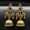 Gold plated bird dangler earrings with pearl and stone work.